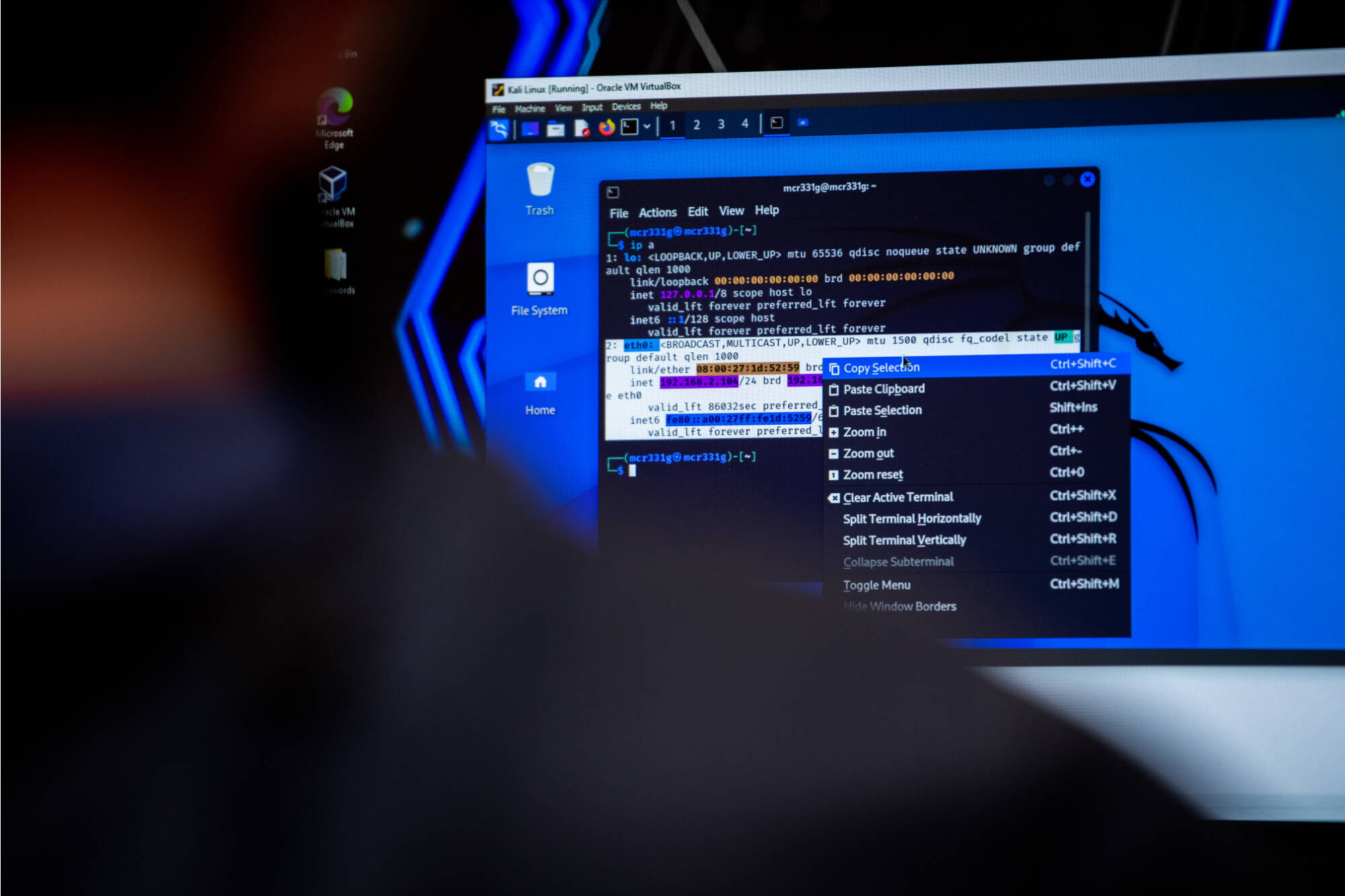 A computer screen displaying a code editor with highlighted programming code and a right-click context menu, viewed over the shoulder of a person.